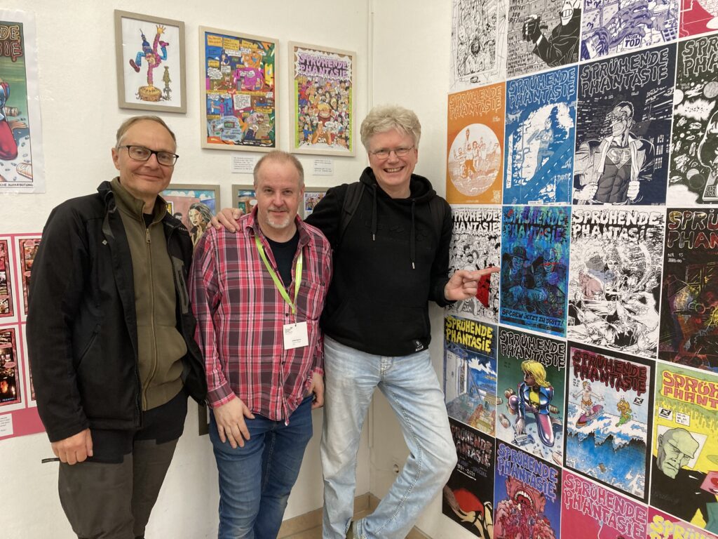 Kim Schmidt, Joachim Guhde und Jens Junge auf dem Comic Salon in Erlangen 2024 in der Ausstellung 40 Jahre Sprühende Phantasie